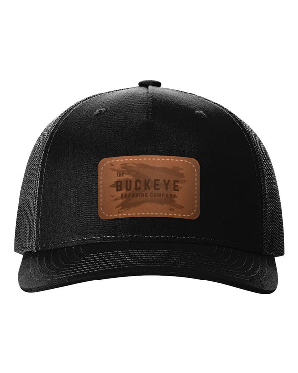 Trucker Cap 112FP in Black with laser-engraved leather patch (sample logo)